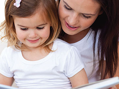 toddler and mother reading together