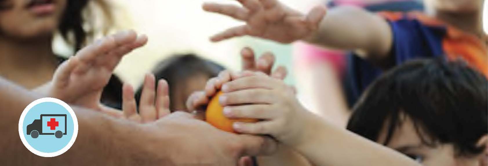 hands distributing oranges in a food distribution