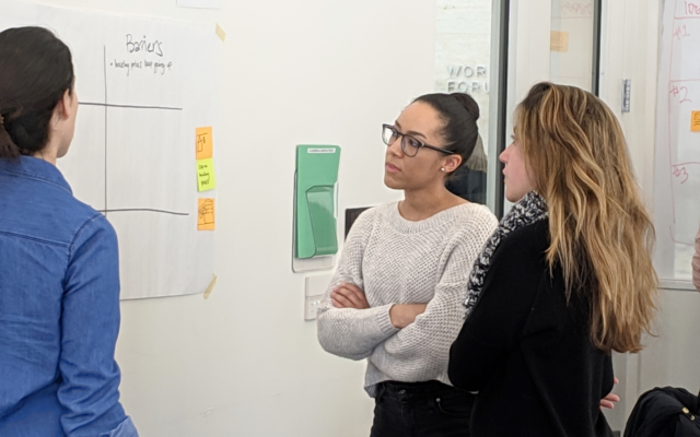 Three female students examining a white board