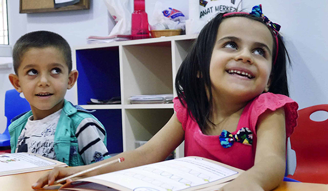 Two children with book in school setting