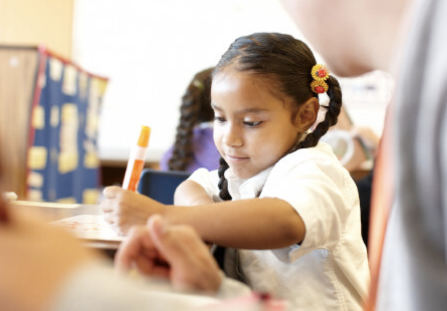 Child with marker being tutored - Reading Partners