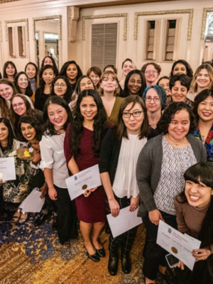 Large group of women in business dress holding diplomas