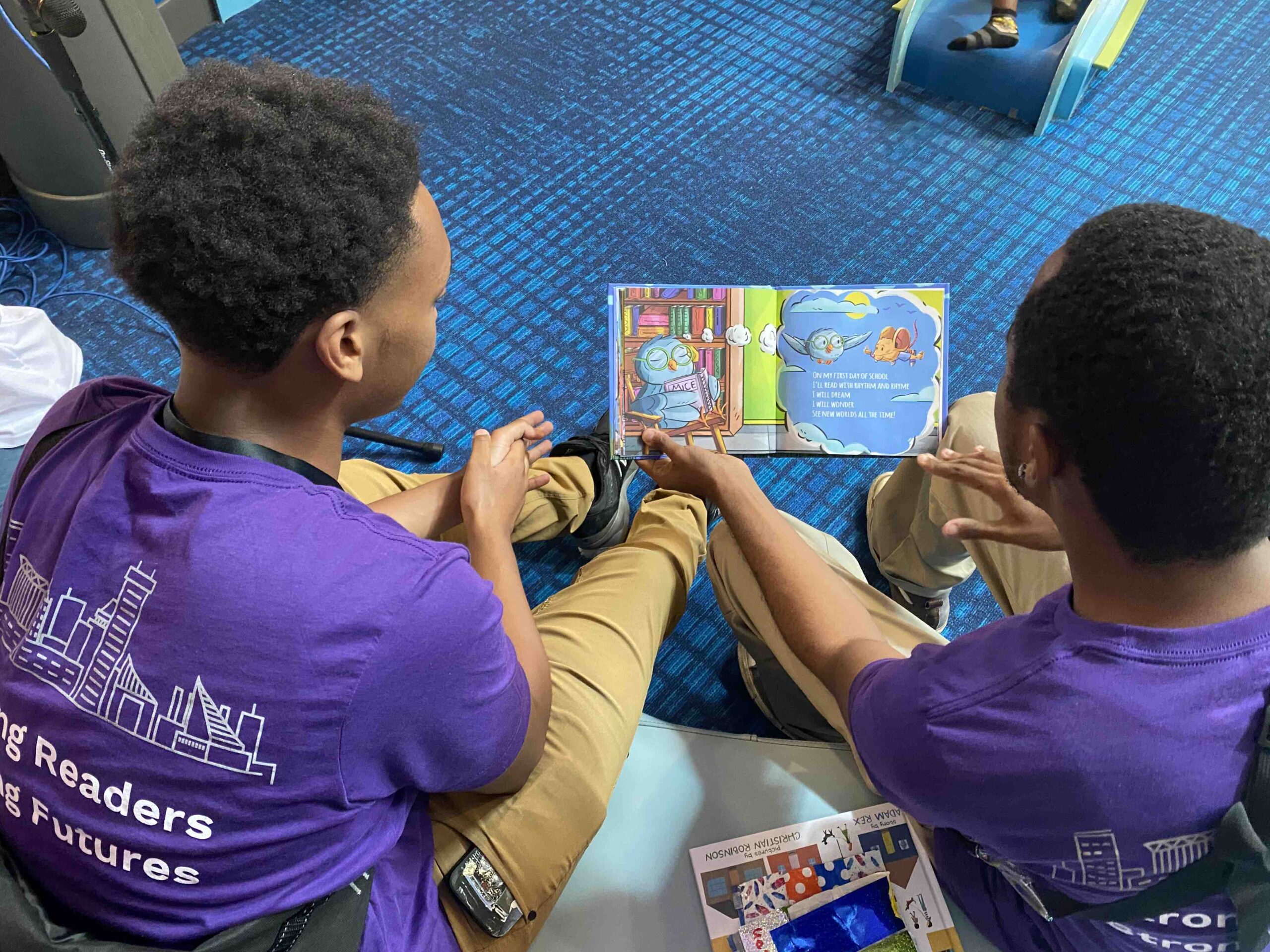 Two young men look at a picture book