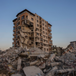 Damaged building surrounded by rubble following the February 2023 earthquakes in Turkey.