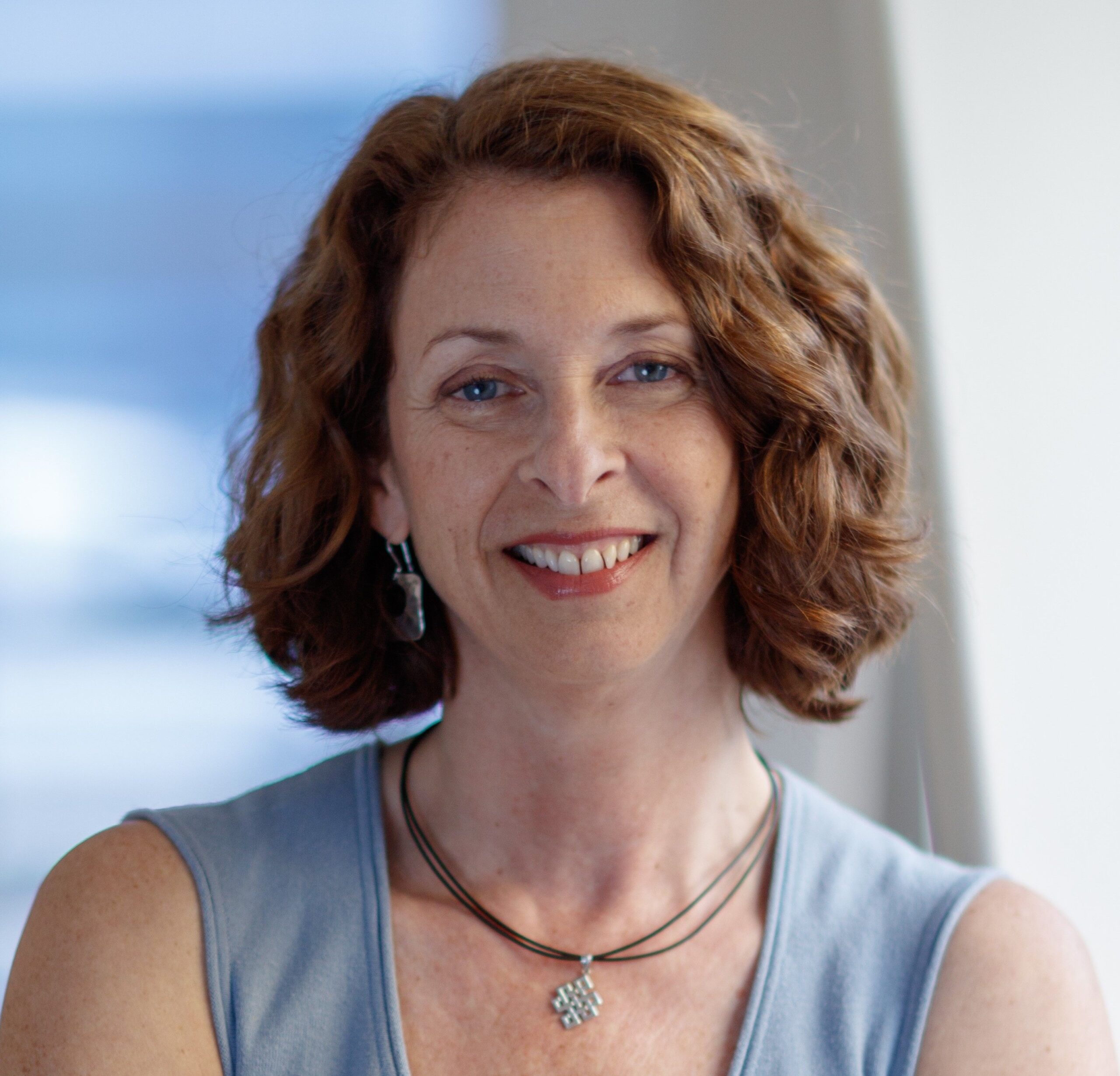 Ruth Shaber in gray sleeveless blouse and pendant