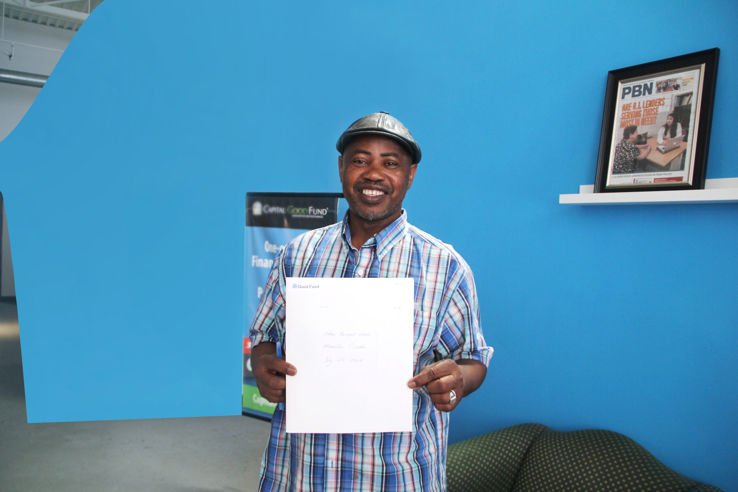 A client of Capital Good Fund holds up a booklet with loan information on it.