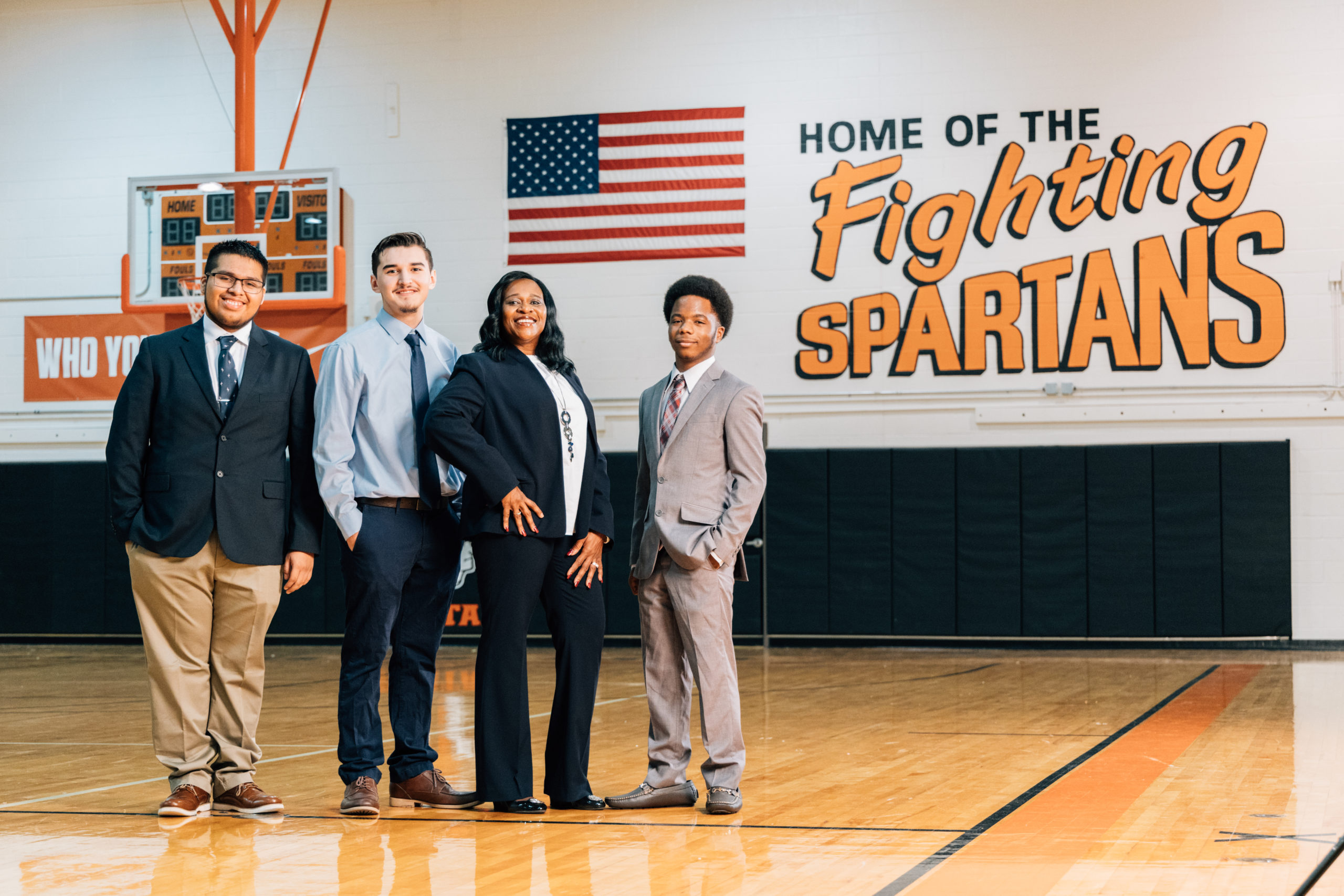 A group of students in suits stand smiling