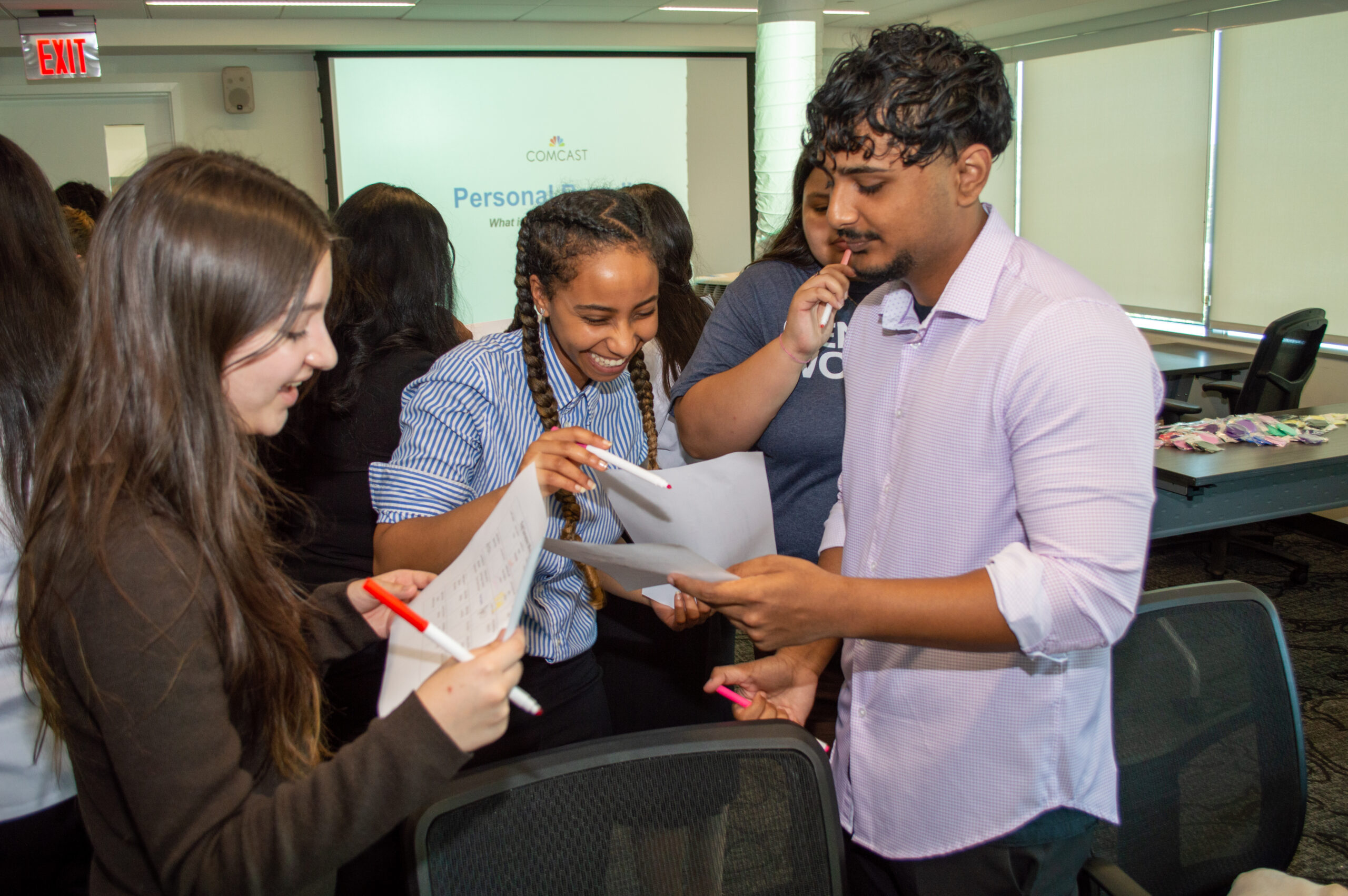 A group of students smiling and talking to each other 