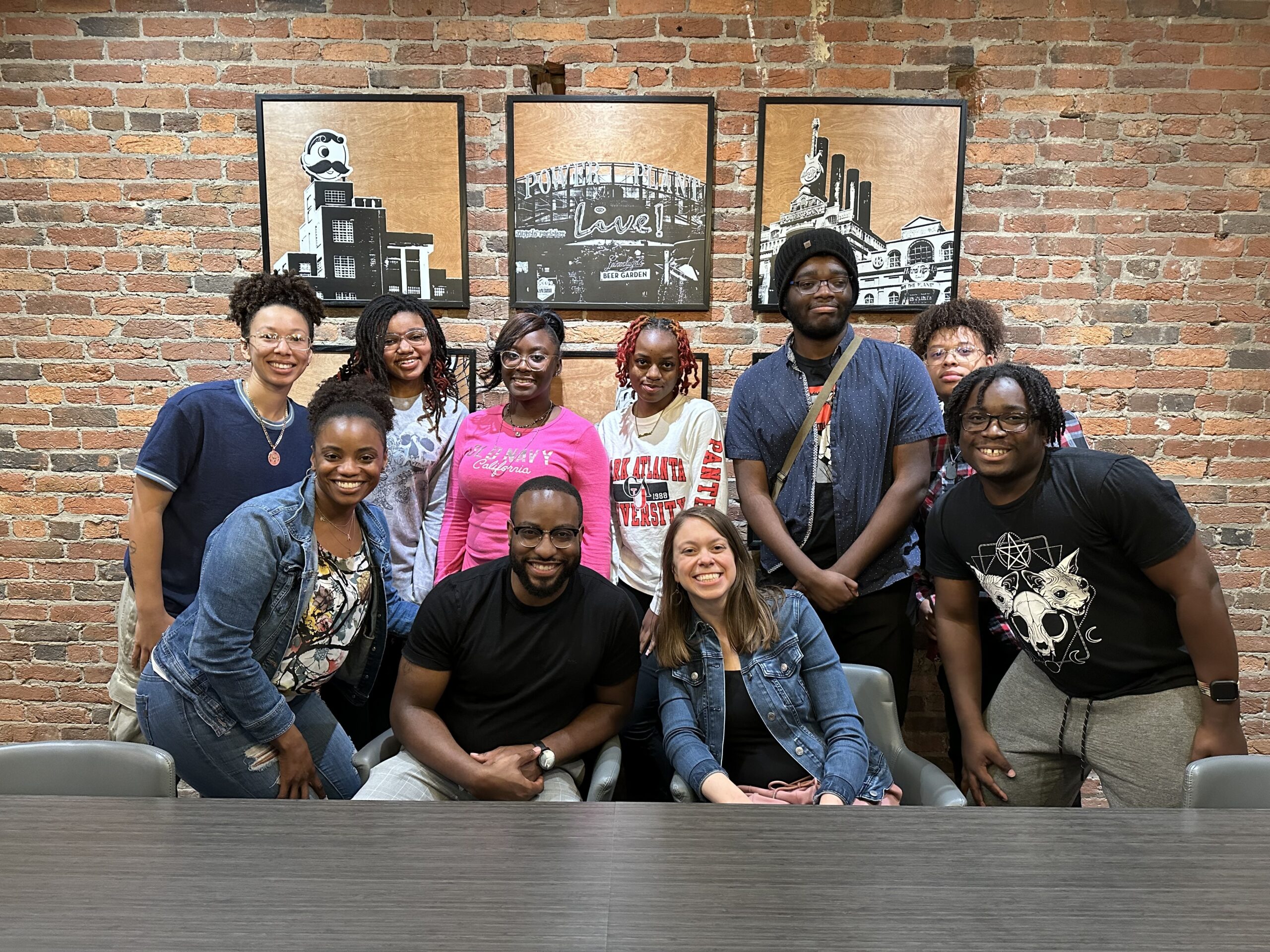 A group of young adults stand together, smiling