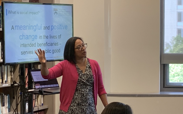 Kat Rosqueta speaking in front of a powerpoint presentation