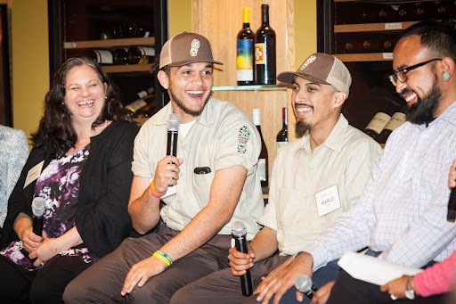 A diverse group of people smile holding microphones